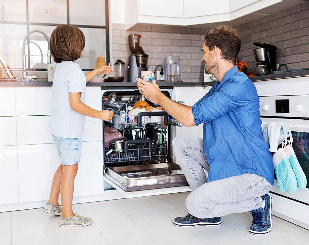 image of caretaker and child loading dishwasher together