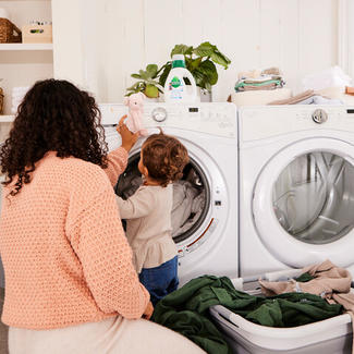 Parent Supervising Toddler at clothes washing machine 
