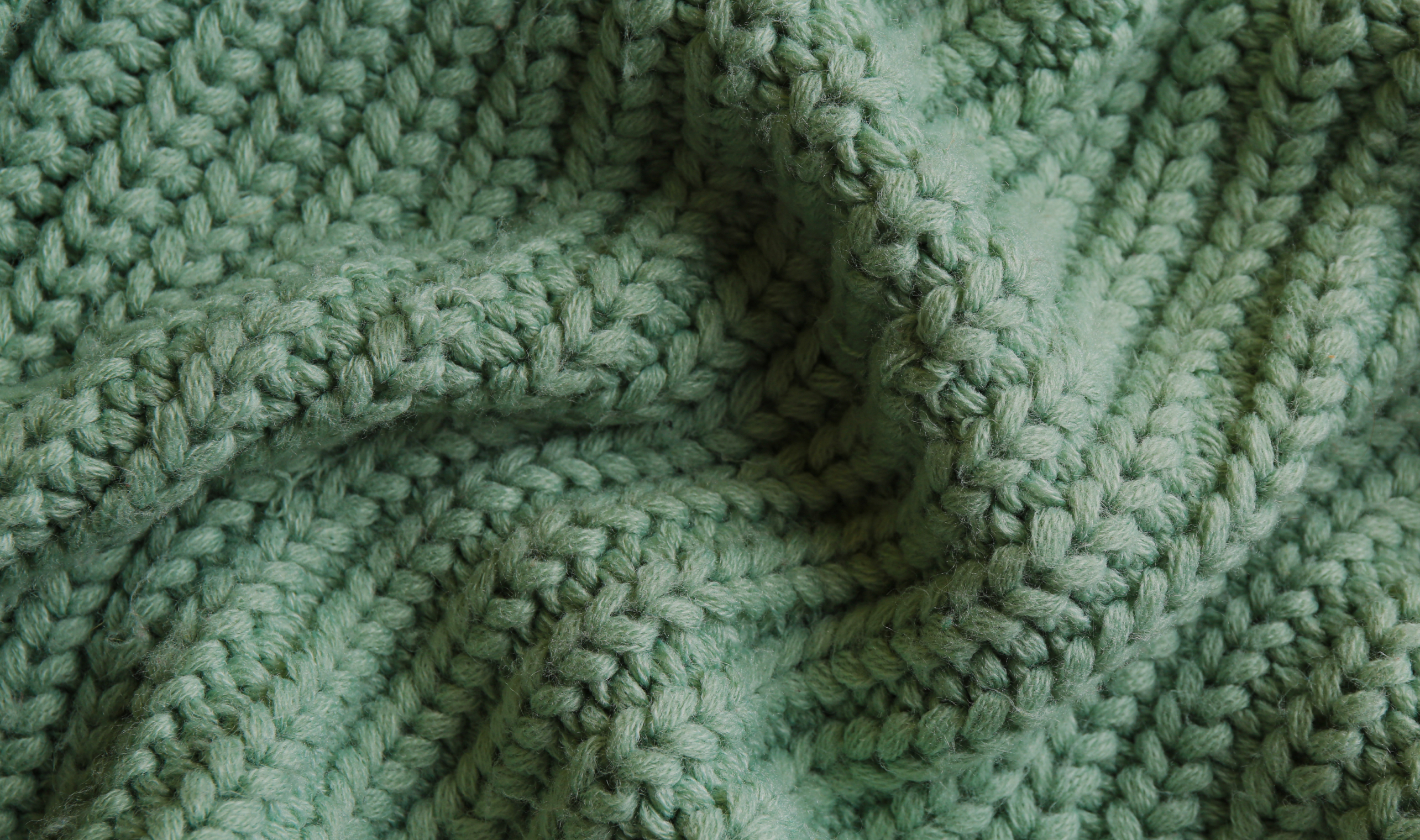 Green Knit Fabric - Blog Header Image for How To Wash Winter Clothes