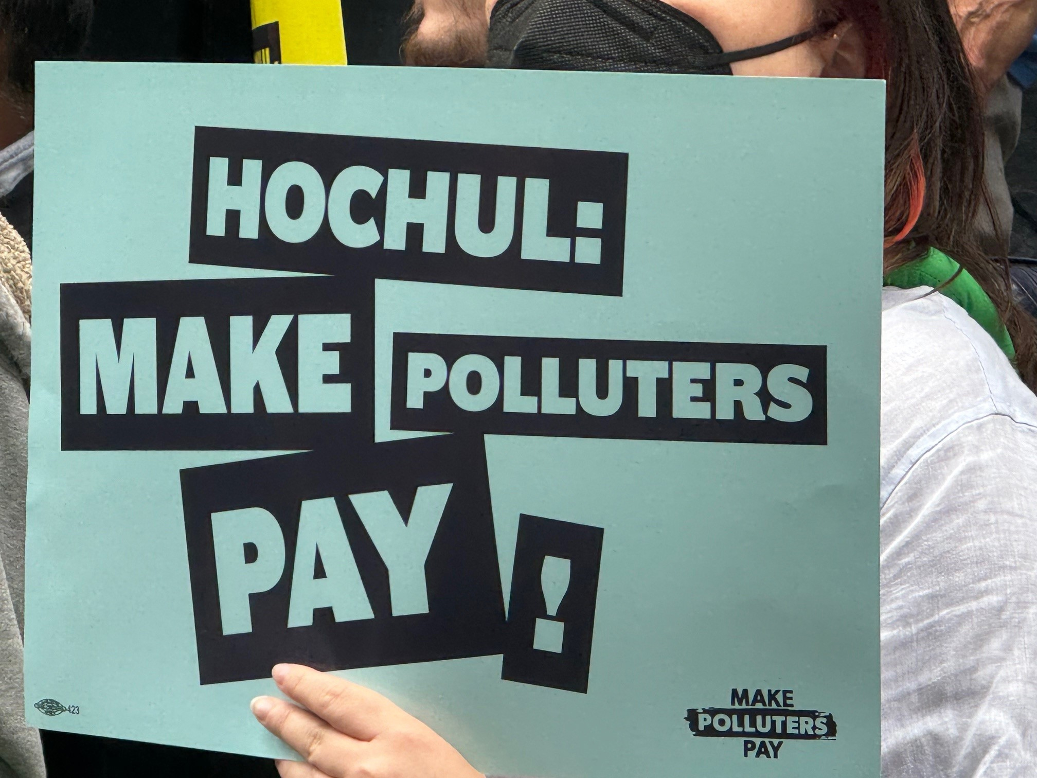 Rally sign reading HOCHUL: MAKE POLLUTERS PAY!