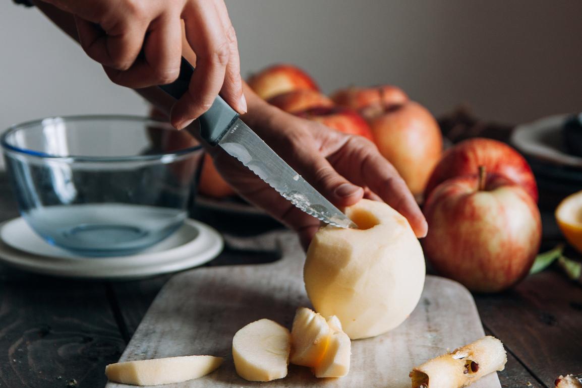 Hands Cutting Skinned Apple