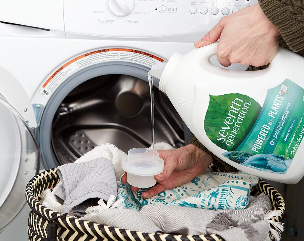 pouring laundry detergent into machine