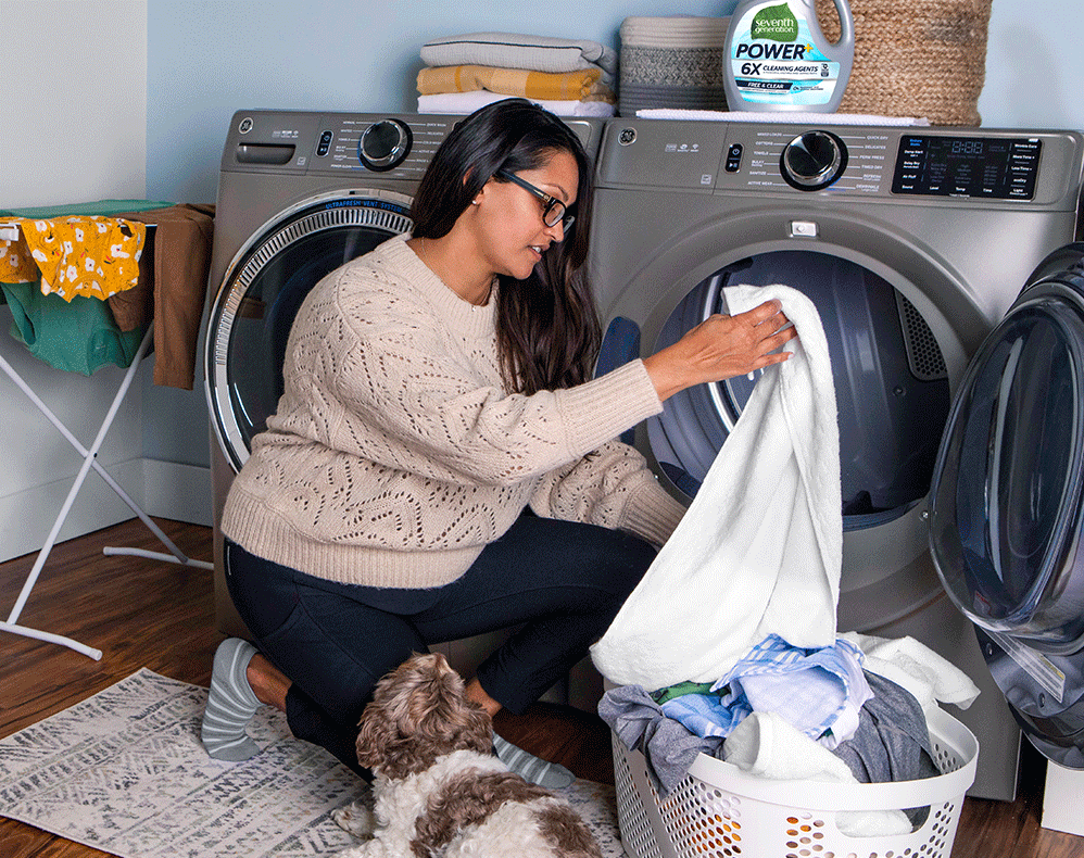 Woman loading clothes in washing machine