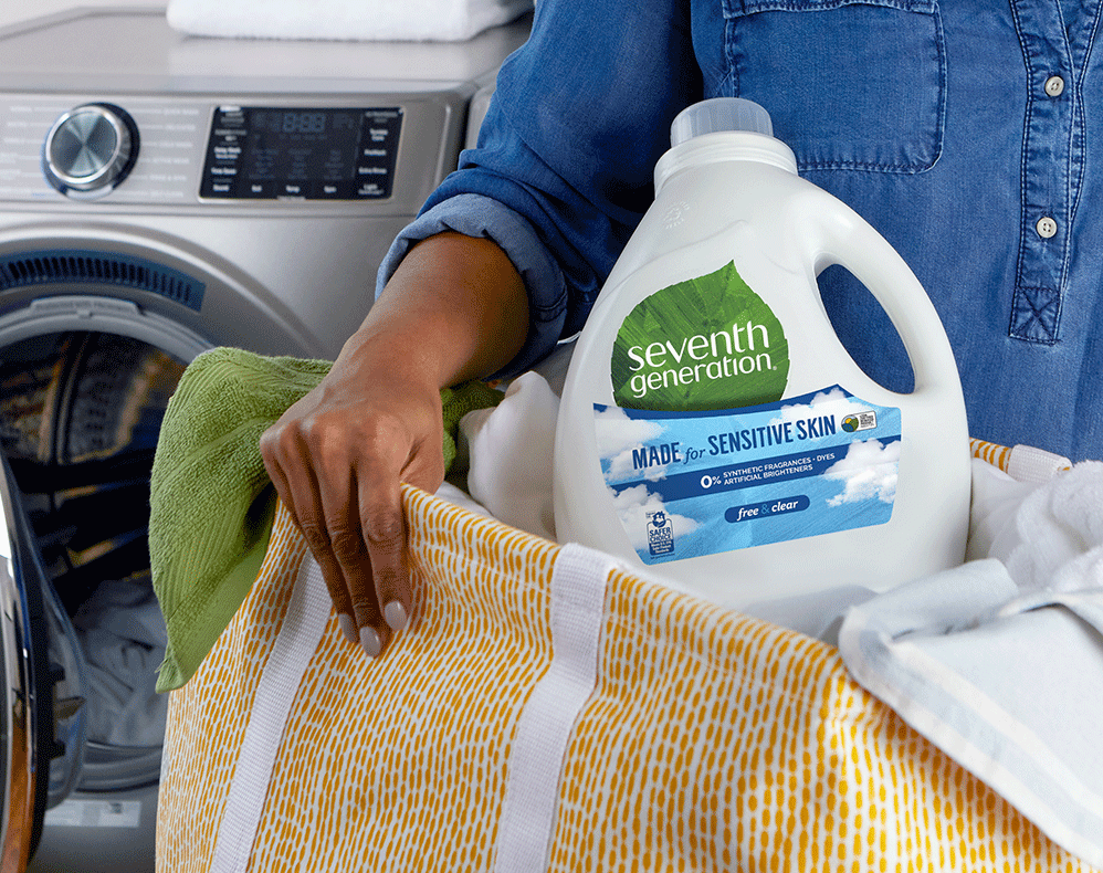 Woman holding laundry detergent in a basket