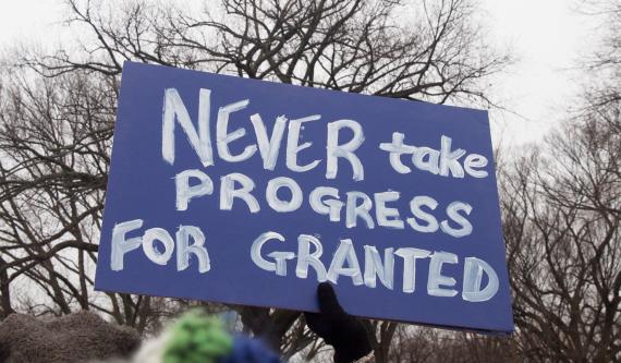 protest sign reads NEVER take PROGRESS FOR GRANTED