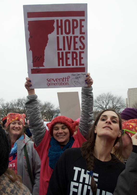 protestors at the Women's march hold a sign reading HOPE LIVES HERE with an outline of Vermont