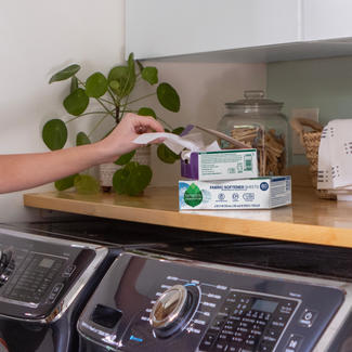 Person pulling fabric softener sheet from box