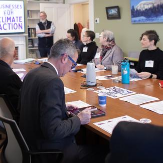 various business representatives at table discussing Climate Action 