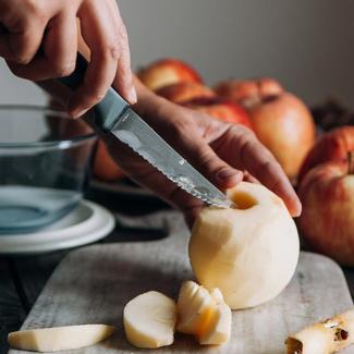 Hands Cutting Skinned Apple