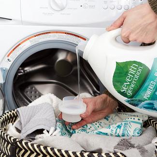 pouring laundry detergent into machine