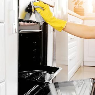 Person cleaning oven with gloves
