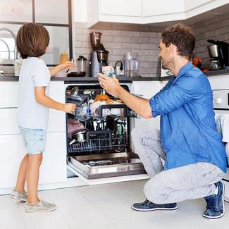 image of caretaker and child loading dishwasher together
