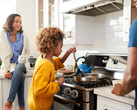 Family cooking together at gas stove