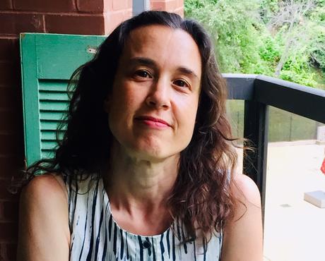 Sarah Newman sitting at table on balcony