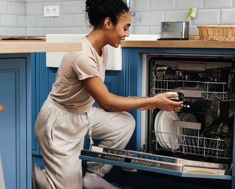 Image of person putting dishes in a dishwasher