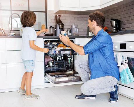image of caretaker and child loading dishwasher together