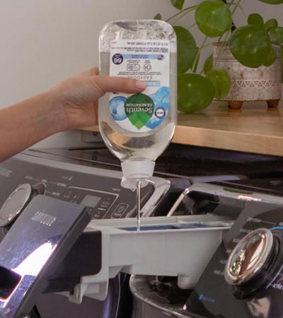 Person adding easy does laundry detergent to high-efficiency washing machine