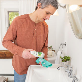 person uses Seventh Generation Zero Plastic Bathroom cleaner