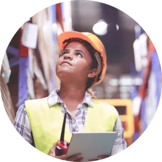 Supply Chain worker wears hardhat and looks up while checking list