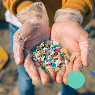 gloved hands cup collection of micro plastics and sand on beach