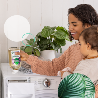 woman doing laundry with baby on hip